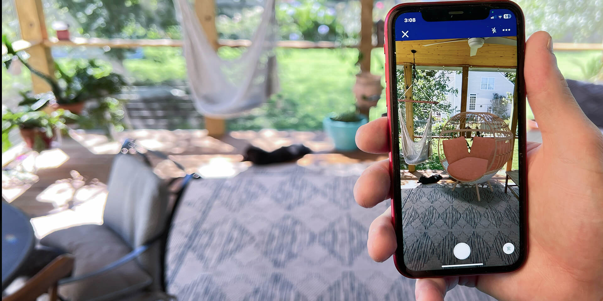 Person holding phone looking at a potential chair option through Lowe's AR visualizer