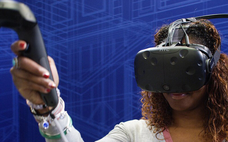 African-American woman wearing VR headset learning DIY skills in a Lowes Home Improvement holoroom