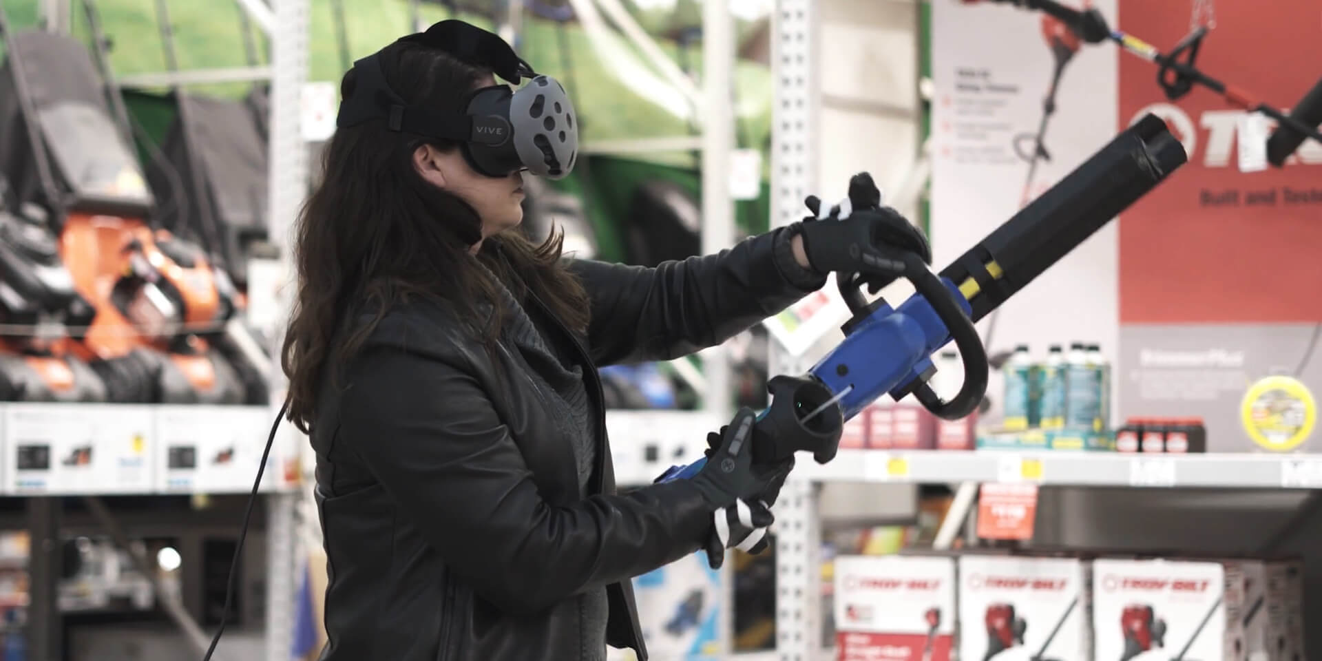 Woman using a VR headset and virtual lawn tool, learning how to correctly trim a hedge in a virtual enviornment